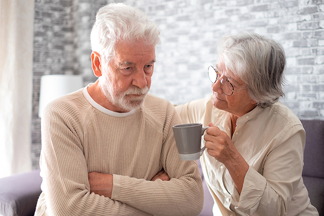 Wife offering cupp of tea to stressed family member